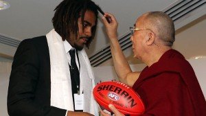 Harry O'Brien entrega uma bola de futebol australiano para o Dalai Lama...